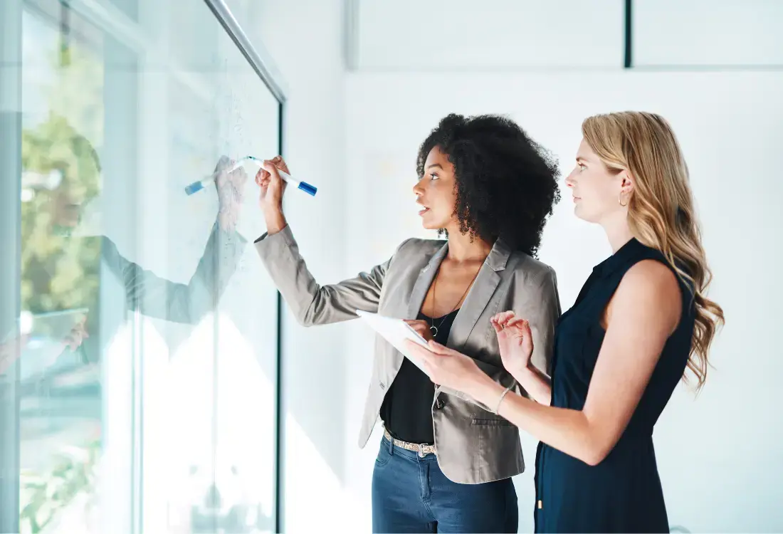 Someone drawing a personal development plan for a manager on a whiteboard  